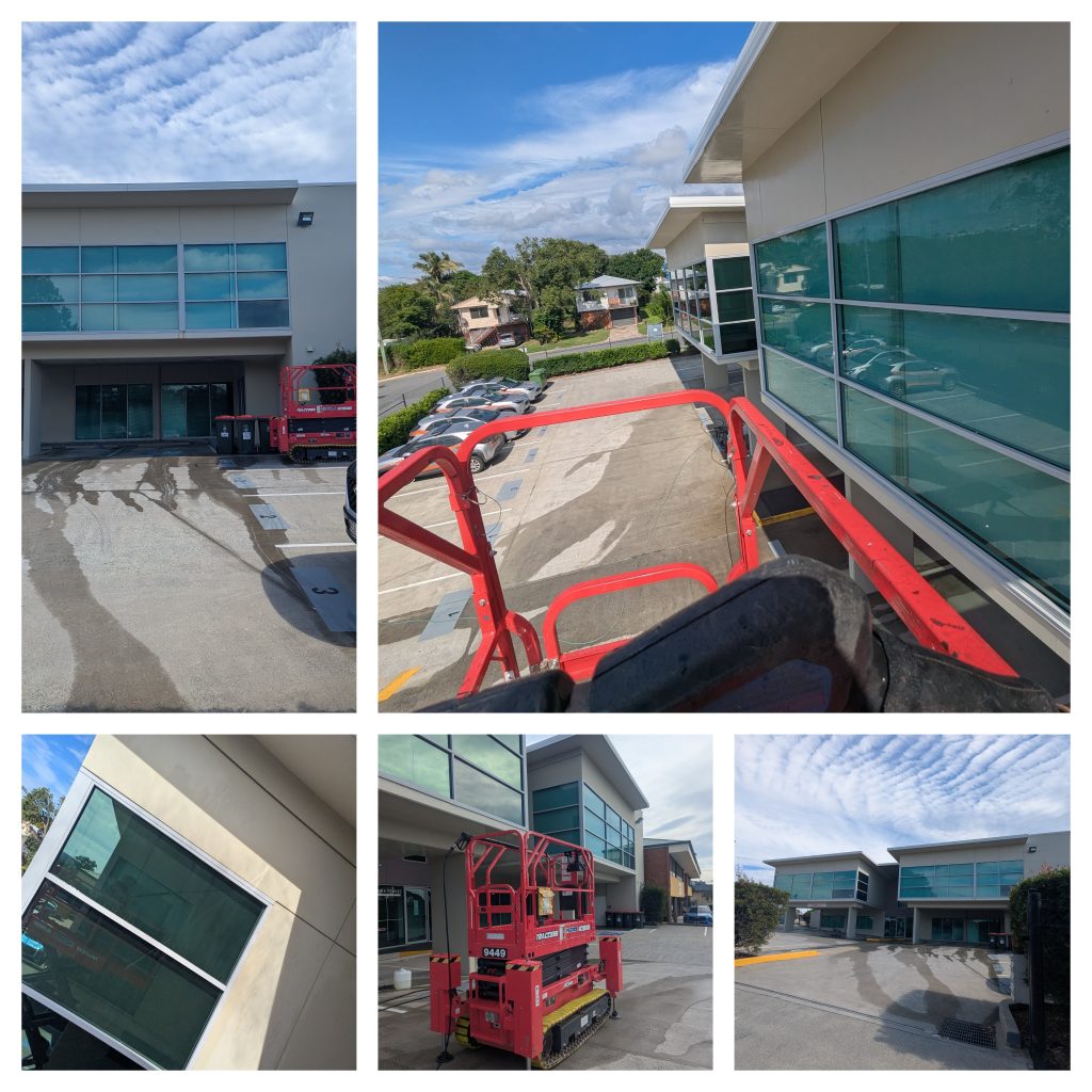 Commercial pressure washing in Brendale using red scissor lift to clean a multi story office building facade.